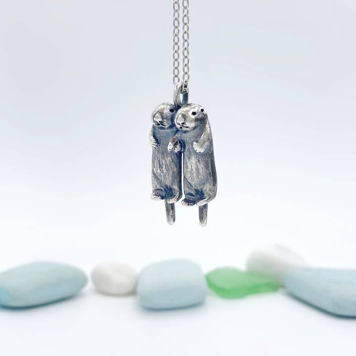 To sølvoddere holder hænder halskæde for engroshandel hos Blue Dot Jewelry