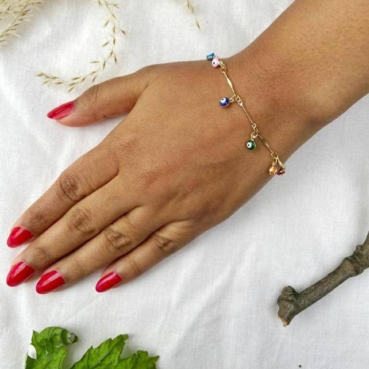 Braccialetto regolabile con ciondolo protettivo occhio malocchio placcato argento, delicato e con perline pendenti. per la vendita all'ingrosso da parte di The Colourful Aura