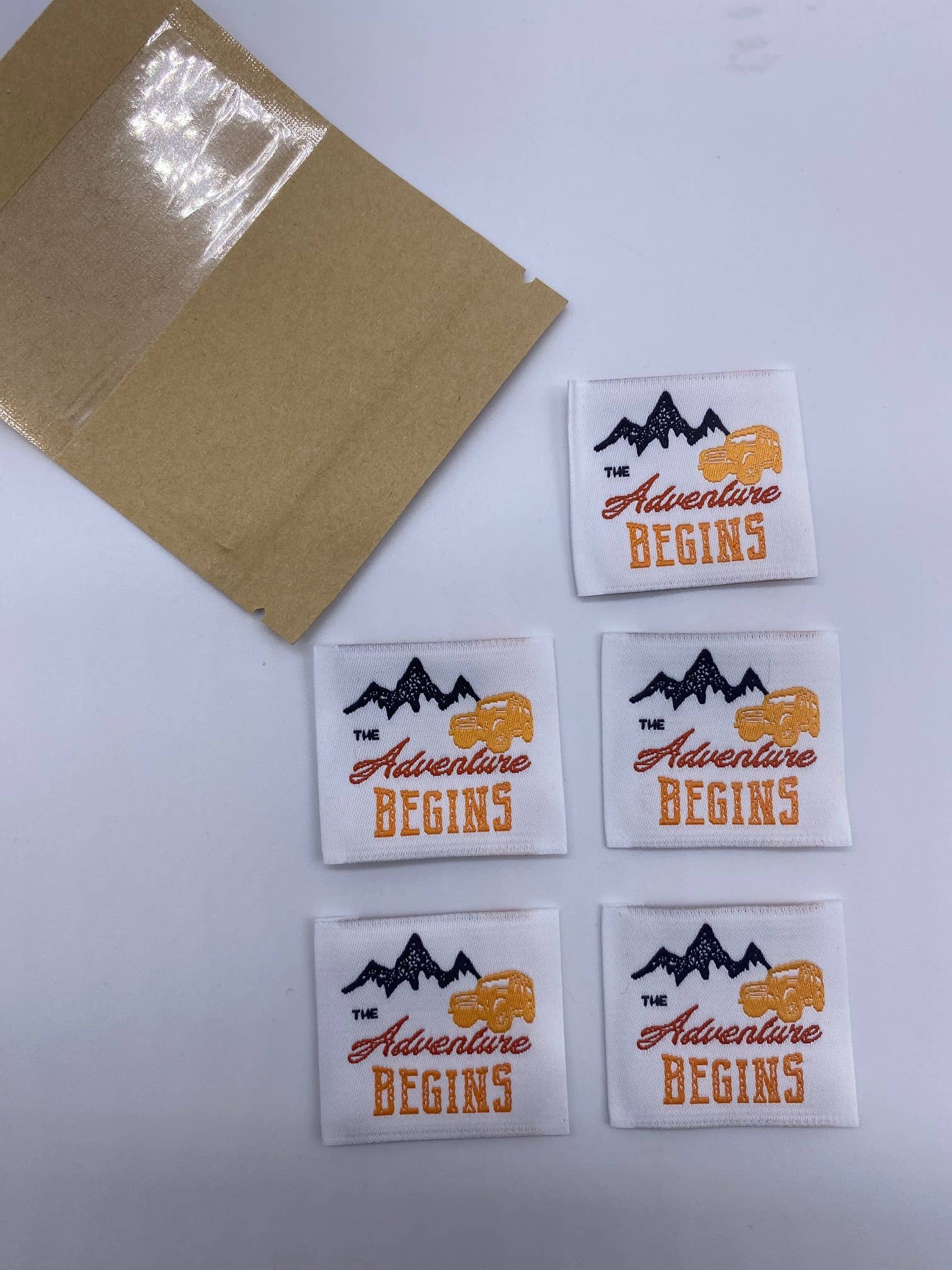 L’Étiquette Home Couture – wholesale Sömnadskit – Vävd etikett att sy på "THE ADVENTURE BEGINS"1