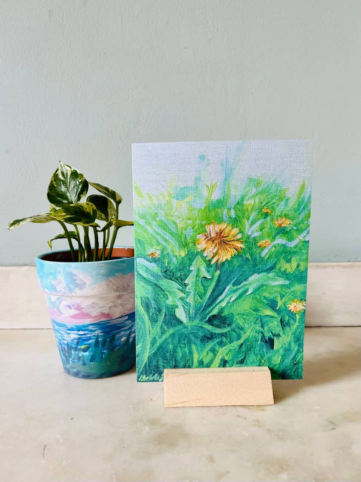 Dandelion in a lush green backyard - blank greeting card for wholesale by Savell Studio