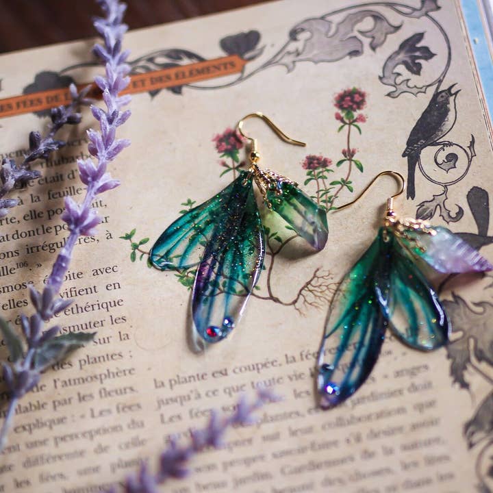 Noëlane - øreringe med eventyragtige vinger i turkis, blå og lilla med aura kvarts for engroshandel hos Faërie
