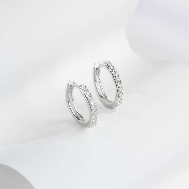 Boucles d'oreilles Huggie classiques en argent pavé de 10 mm pour la vente par Wanderlust + Co