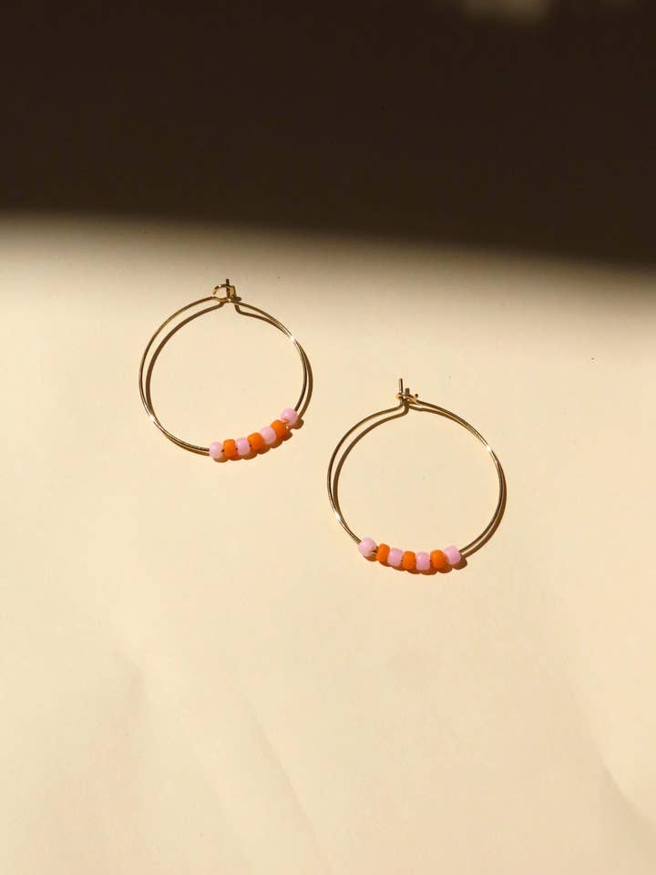 Stainless steel hoops with pink and orange Toho Seed beads for wholesale by Niemalsmehrohne