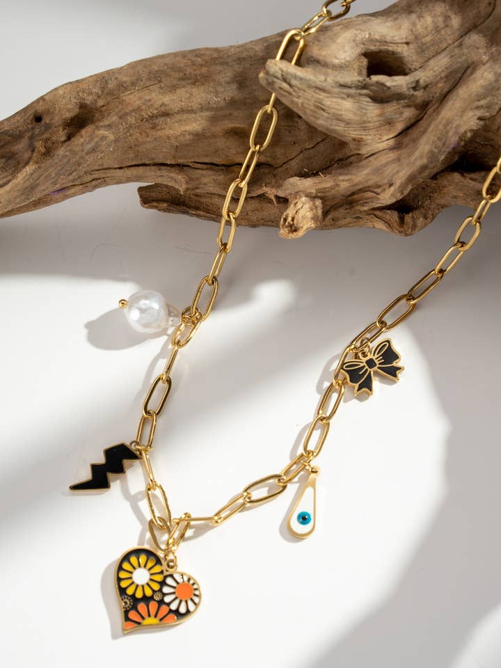 Golden necklace with graphic charms: heart, flower, eye, lightning. for wholesale by COSMOS