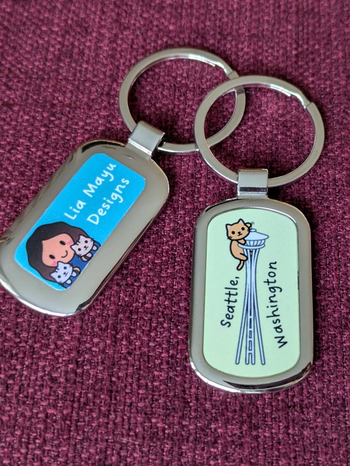 Orange cat on the Seattle Space Needle metal keychain for wholesale by Lia Mayu Designs