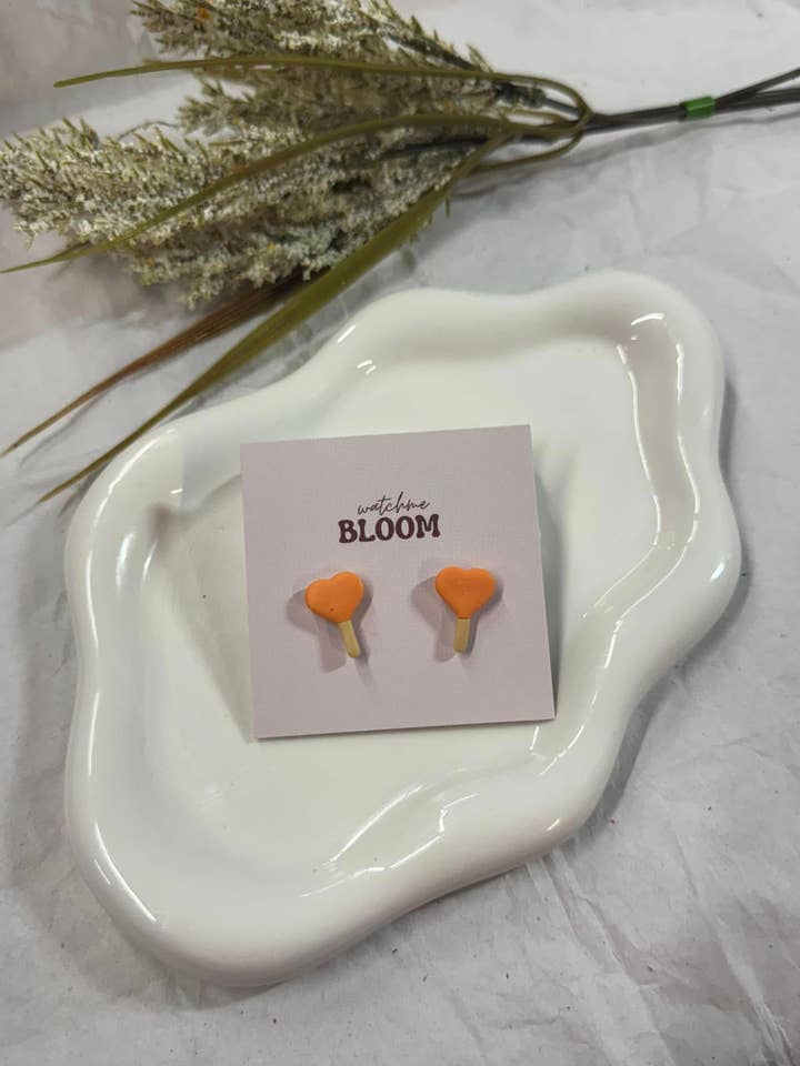 Clous d'oreilles en argile polymère en forme de sucette cœur pour la vente par Watch Me Bloom