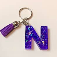 Mousserende lilla brev nøglering for engroshandel hos Shop Drip Express