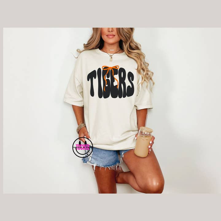 Tucker with a Tee - Venta al por mayor Camiseta estampada - Mujer - Camiseta de colores cómodos con mascota de tigres preppy y lazo