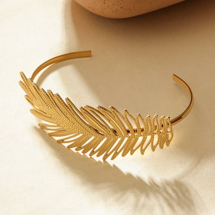 Bracciale aperto dorato con motivo foglia tropicale per la vendita all'ingrosso da parte di JOYA