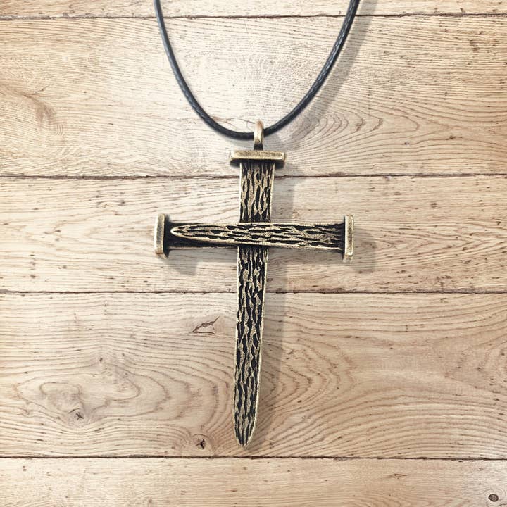 Ciondolo Croce Chiodo Leo in Ottone Antico con Cordino Nero per la vendita all'ingrosso da parte di Forgiven Jewelry