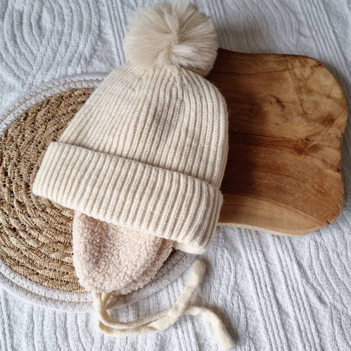 Vinter Bästsäljare Vinterhatt för spädbarn med öronskydd och pompom - Beige för wholesale av Rammelaartje