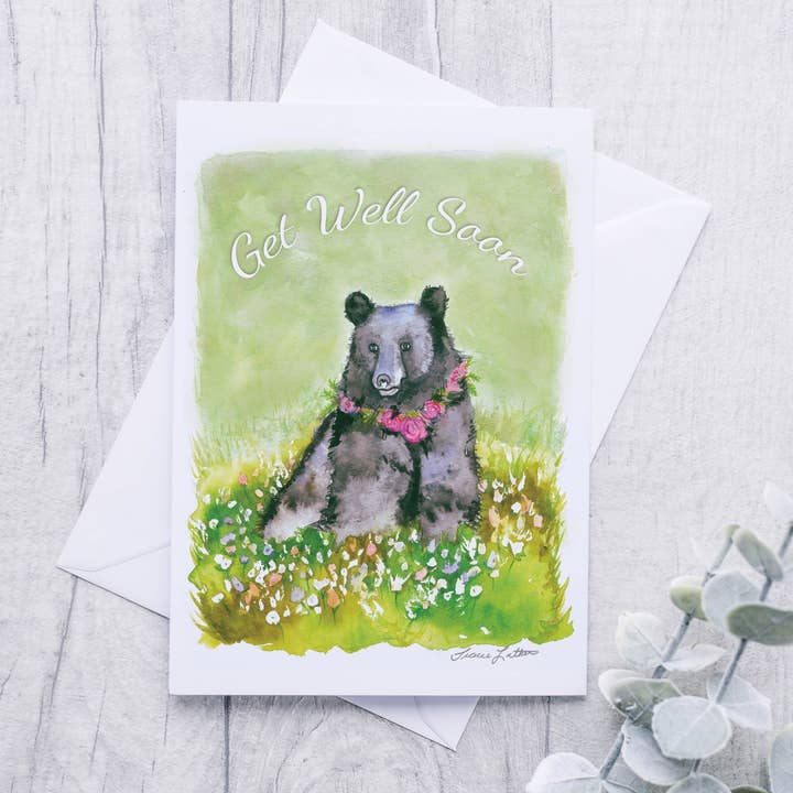 Schwarzbär mit Blumenkette „Get Well Soon!“ Grusskarte für den Großhandel von Cloud Cottage Creative Company