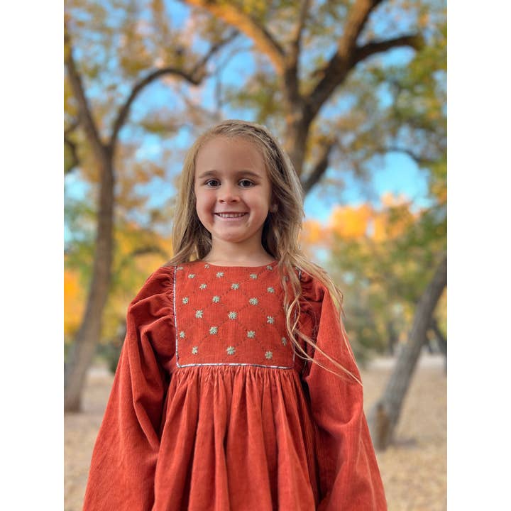 Gathered sleeve embroidered dress in rust color needlecord for wholesale by Poppet & Fox