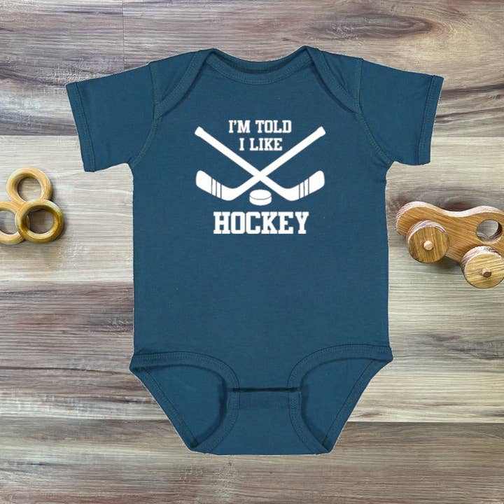 I'm Told I Like Hockey Silhouette Baby Bodysuit for wholesale by Rocket Bug