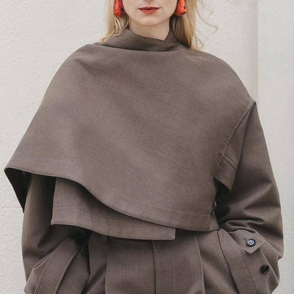 Trench capispalla con colletto alla coreana in tinta unita con tasche larghe asimmetriche a maniche lunghe per la vendita all'ingrosso da parte di UZ Wholesale Store