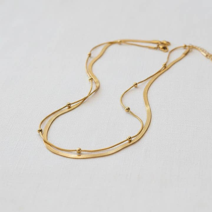 Collier à perles dorées superposées et chaîne serpent. pour la vente par paperln