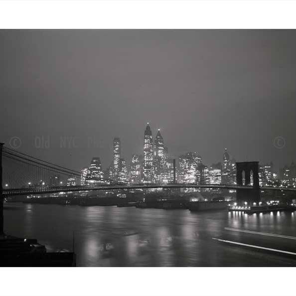 Manhattan se ilumina por la noche con el puente de Brooklyn en primer plano para venta al por mayor de Old NYC Photos