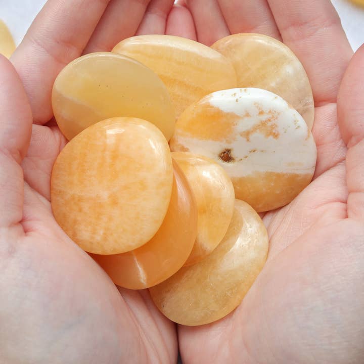 Orange Calcite Palm Stone for wholesale by Natures Artifacts Inc