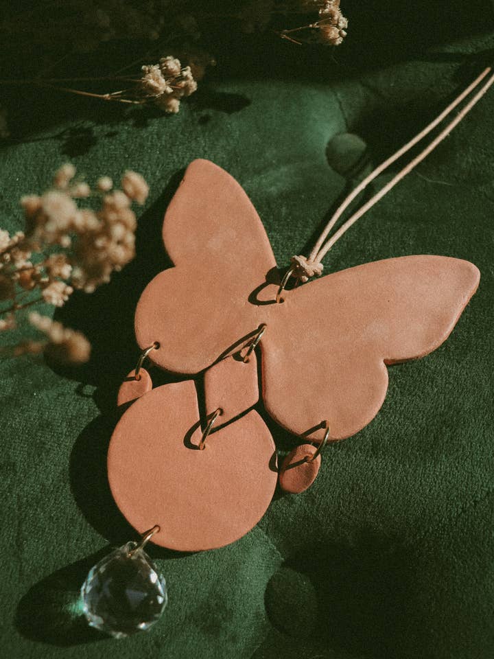 Piccola decorazione da parete in terracotta a forma di farfalla con acchiappasole per la vendita all'ingrosso da parte di Rooted Reverie