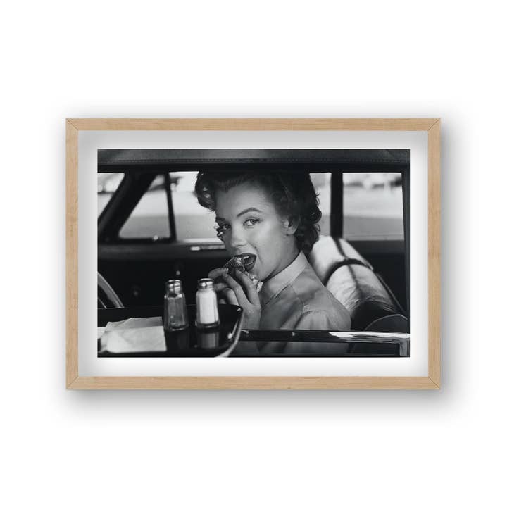 Gallery Print and Art - Vendita all'ingrosso Stampa artistica - Ritratto di Marilyn Monroe in macchina mentre mangia hamburger con stampa di icone vintage drive-thru