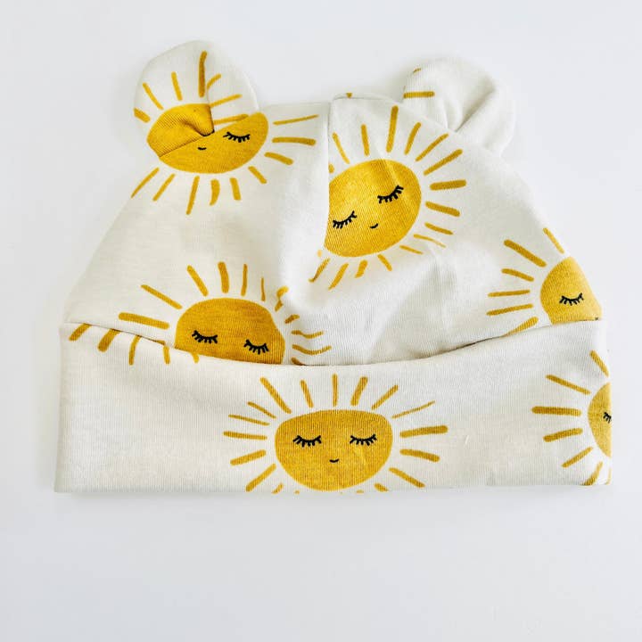 Bonnet pour bébé en coton biologique Eddie & Bee avec oreilles, imprimé "Sunny" avoine. pour la vente par Eddie & Bee