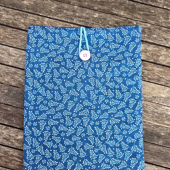 Polstret bogomslag med hvide og lyserøde grene, blå baggrund for engroshandel hos laubelgo