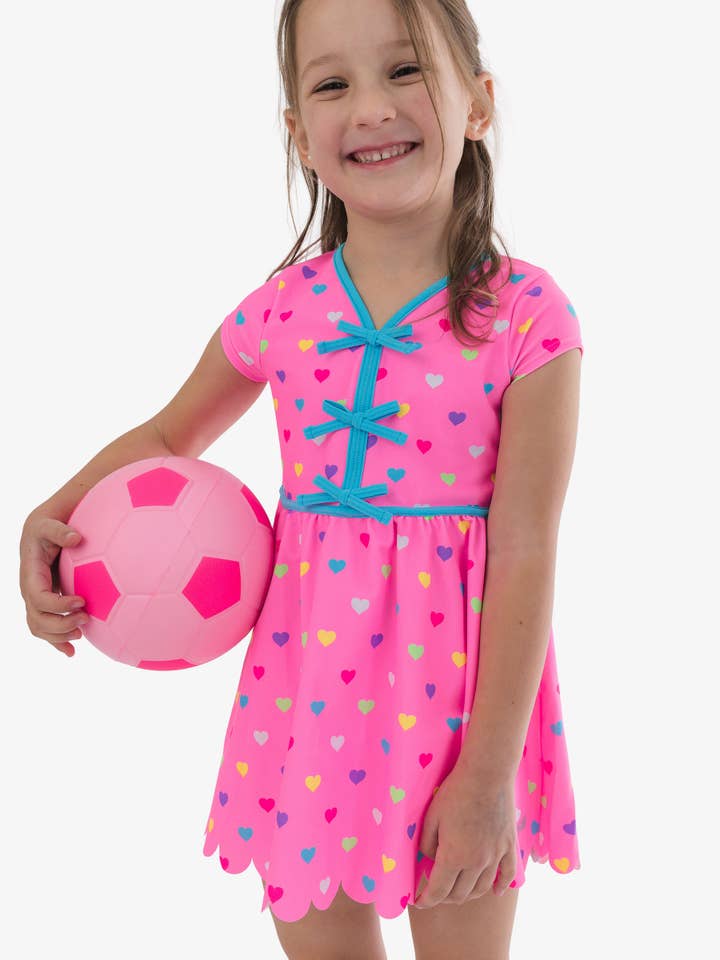 Conjunto de Vestido Activo de Manga Corta con Lazo y Pantalones Cortos de Bicicleta para Niñas en Color Rosa Neón con Corazones Coloridos para venta al por mayor de RuffleButts + RuggedButts