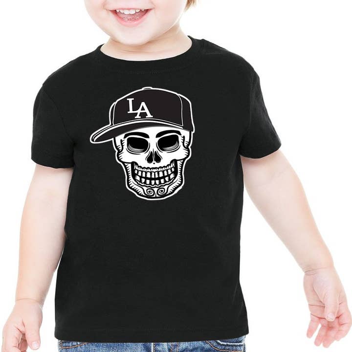 „Spiel Ball!“ Baby Tag der Toten LatinX T-shirt für den Großhandel von Bronze Baboon