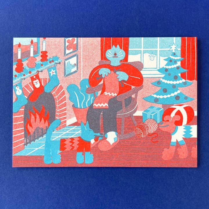 YUK FUN Christmas Card - Cozy Winter Indoor Knitting Scene for wholesale by YUK FUN