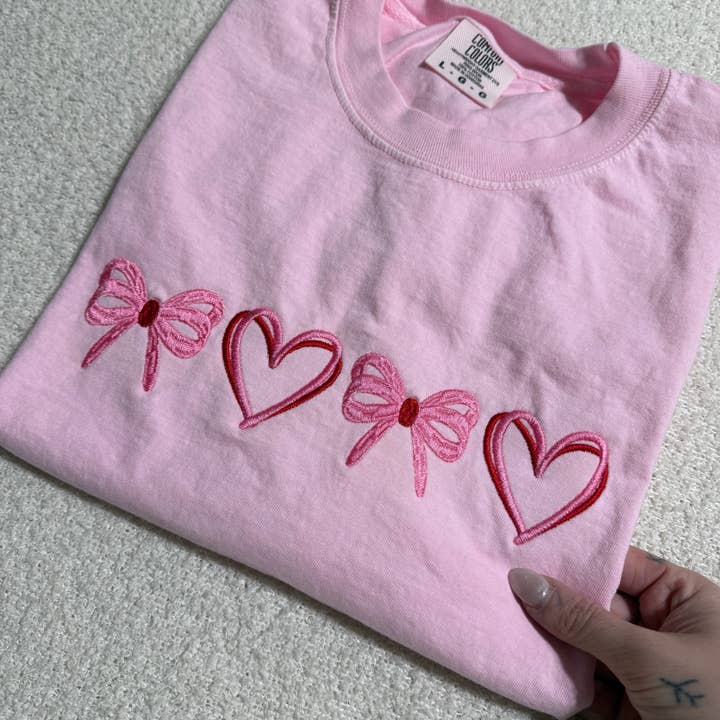 Delikat koket hjerte valentinsbroderet t-shirt. for engroshandel hos Basil & Burch