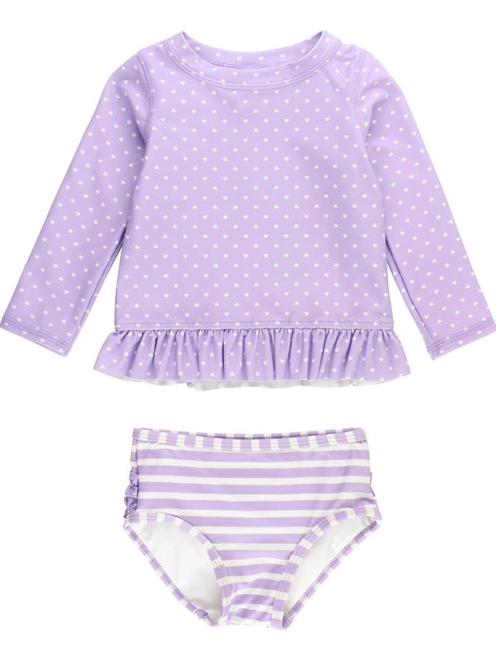 Conjunto de baño de dos piezas con protector solar de manga larga y estampado de corazones y lunares en lavanda para niñas, con volantes traseros característicos. para venta al por mayor de RuffleButts + RuggedButts