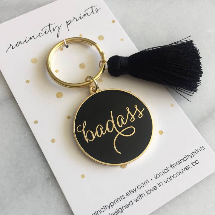 Badass - Emalj nyckelring - finns i svart och rosa för wholesale av Raincity Prints
