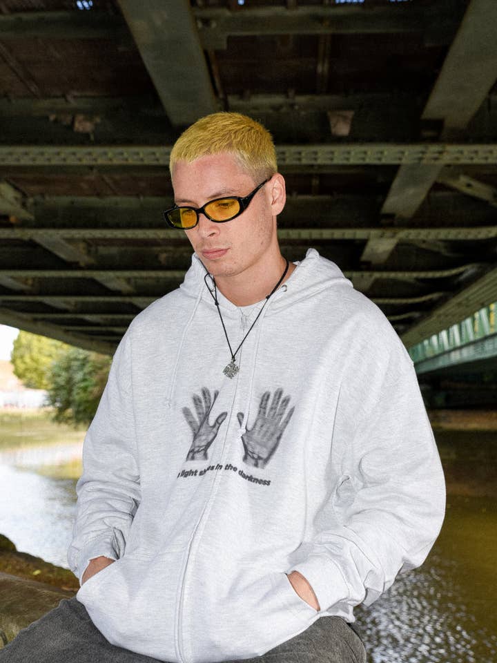 Zip Hoodie in Ash Grey with A Light Shines In The Darkness Print for wholesale by Dream But Do Not Sleep