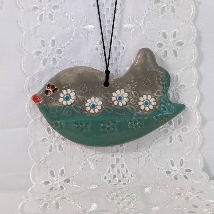 Handmade ceramic teal and gray bird ornament with daisy trim for wholesale by CurlyFernCeramics
