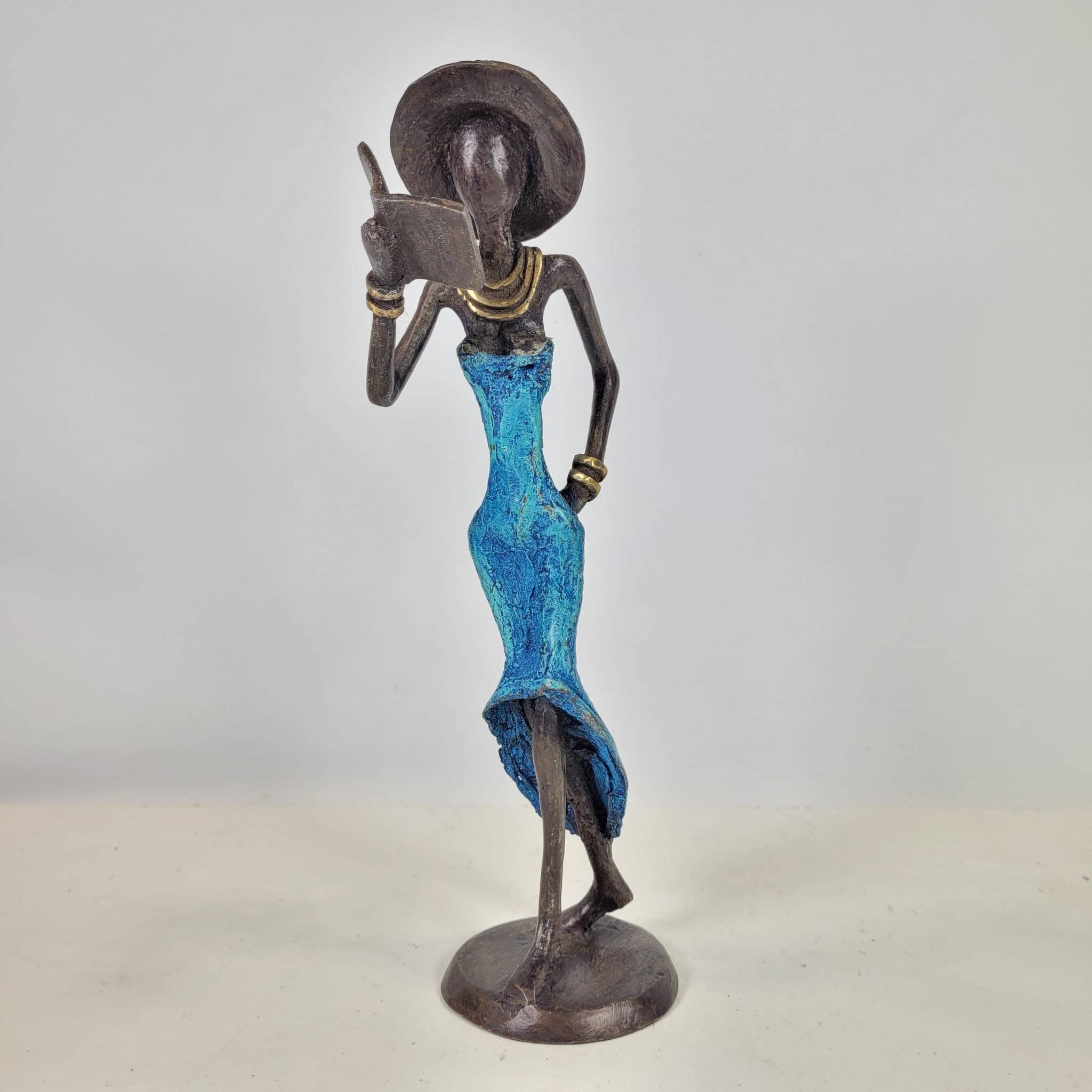 Moogoo Creative Africa - Wholesale Sculpture - Bronze sculpture “Femme avec livre et chapeau” by Soré | vers0