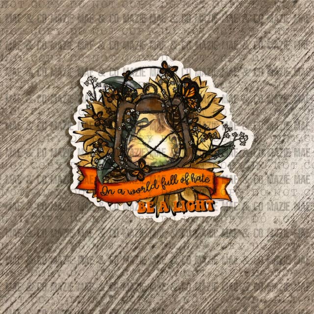In a World Full of Hate, Be a Light Sticker for wholesale by Mazie Mae & Co