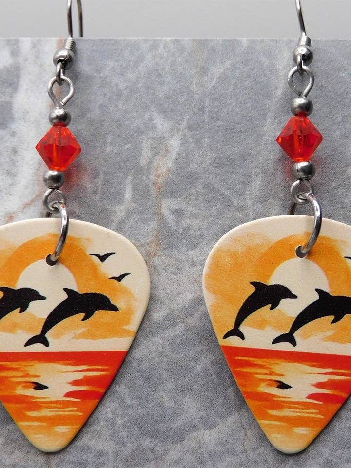 Jumping Dolphins Guitar Pick Earrings with Orange Swarovskis for wholesale by Simply Raevyn