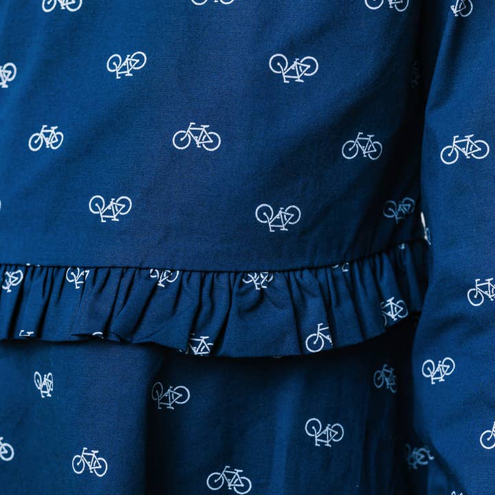 Navy Bicycle Print Ruffle Waist Dress - Made with Organic Cotton for wholesale on Faire