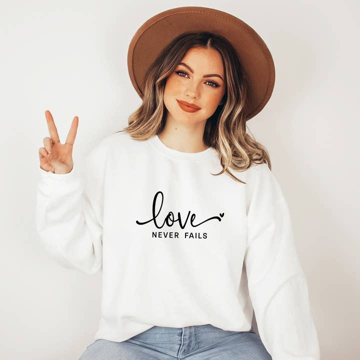 Love Never Fails | Sweatshirt | Religious | Faith |Uplifting for wholesale by Uplifting Threads Co Wholesale