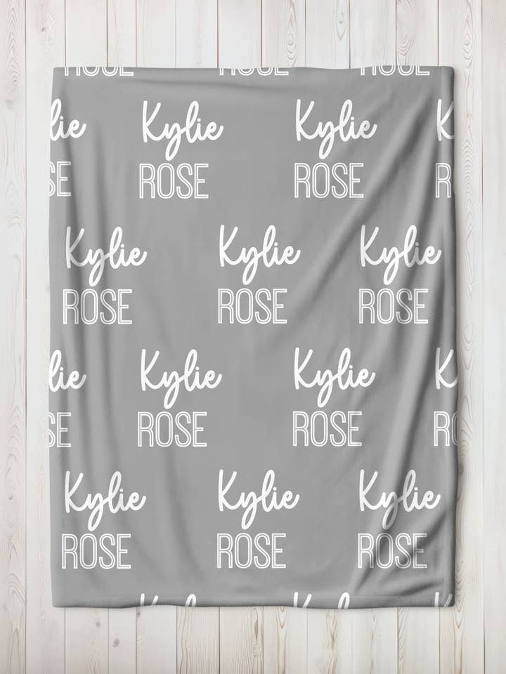 Manta de bebé personalizada de color gris claro con nombre repetido para venta al por mayor de Monogram Junkie
