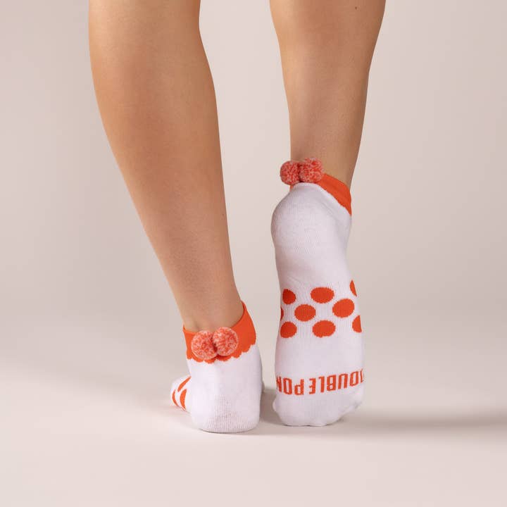 Signature Athletic Knöchelsocke mit orangefarbenem Besatz und doppelten orangefarbenen Konfetti-Poms. für den Großhandel von Double Pom
