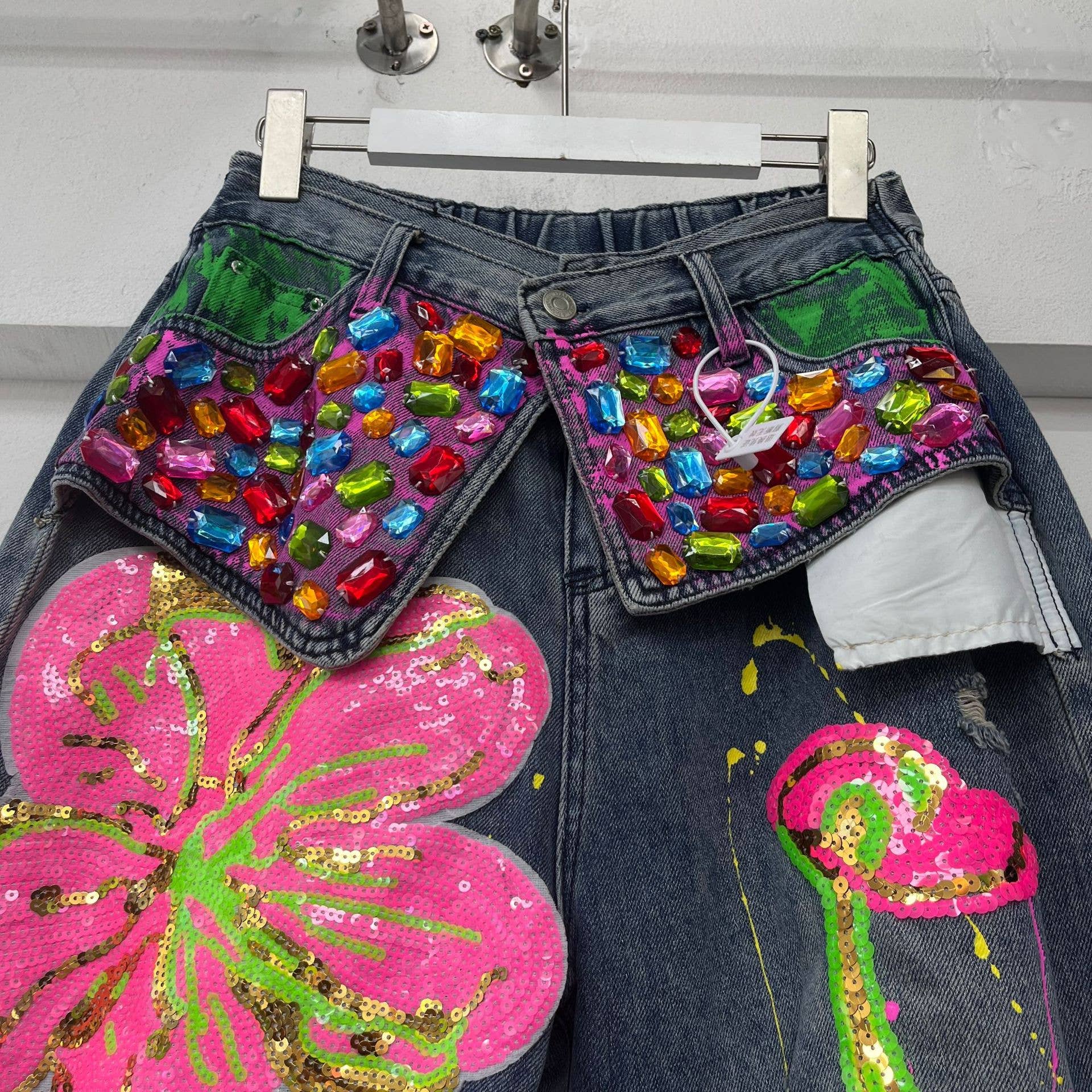 Blu scuro Jeans strappati con stampa floreale, paillettes e strass colorati. in vendita all'ingrosso su Faire3