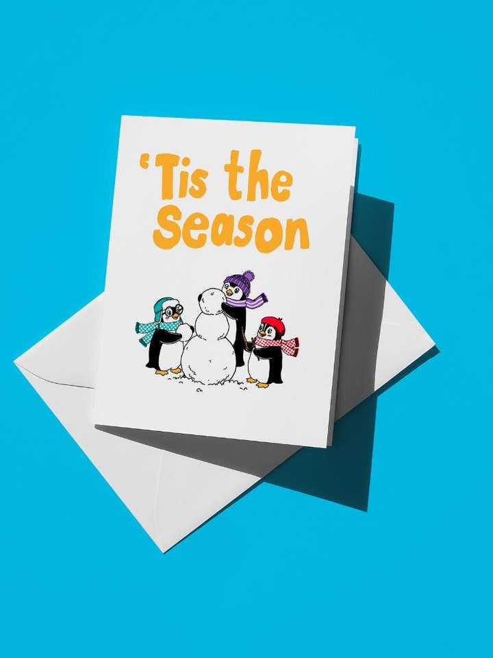 È la stagione delle feste invernali - Cartolina con pinguini che costruiscono un pupazzo di neve | A2 5,5"x4,25" Cartolina di auguri vuota con buste | Cartoncino opaco premium per la vendita all'ingrosso da parte di semiserious studio