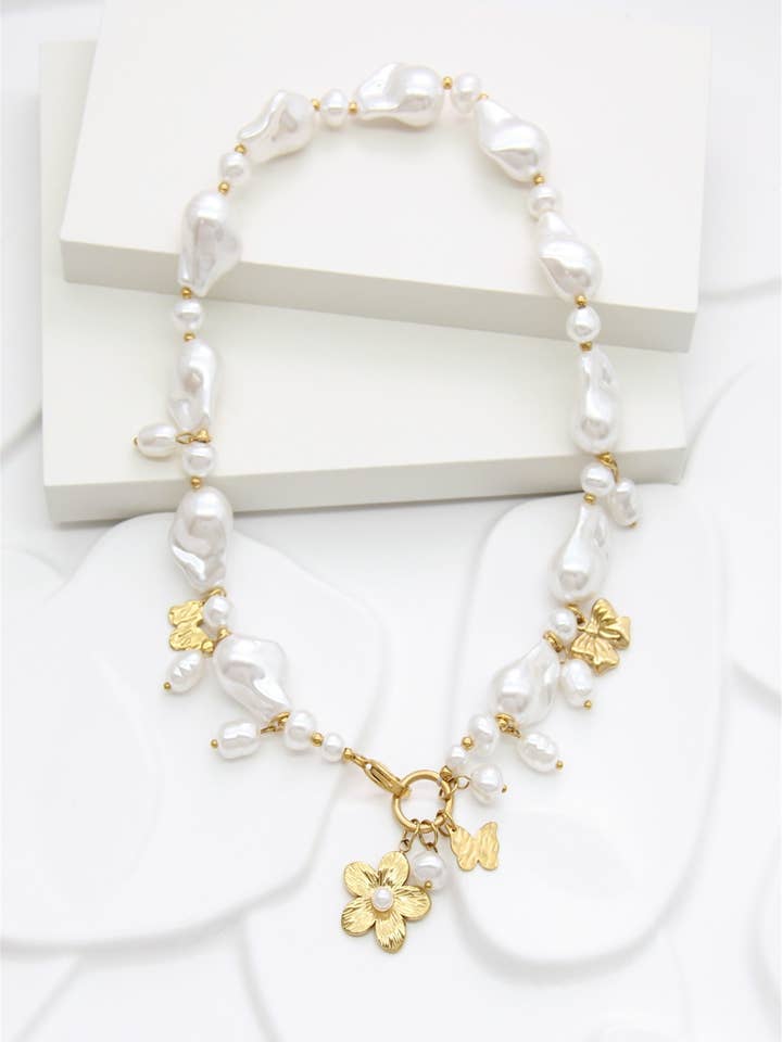 Irregular white pearl necklace with golden flower charms for wholesale by BELLISSIMA BIJOUX