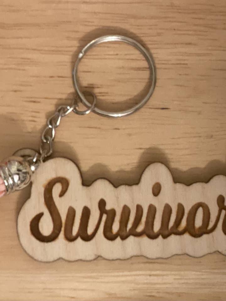 Survivor Schlüsselanhänger aus Holz mit Gravur und Quaste für den Großhandel von Neat Creations