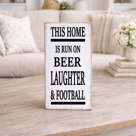 THIS HOME IS RUN ON BEER LAUGHTER & FOOTBALL for wholesale by Dudley's Cottage & Gifts