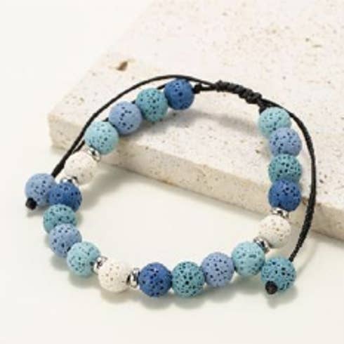 Round bead bracelets in natural lava stone tinted white with blue shades for wholesale by INNOBIZ