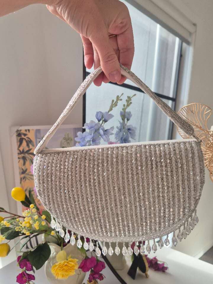 Perlenhandtasche in Weiß mit Quasten unter dem Arm für den Großhandel von Melci Studio