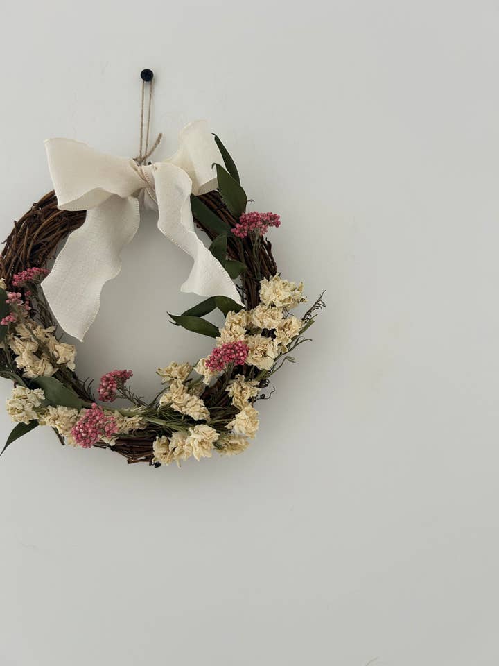 ‘Everlee’ Wreath with White Delphinium, Pink Rice Flowers and Ruscus finished with a cream bow 20cm for wholesale by Cotswolds Willow Wreaths
