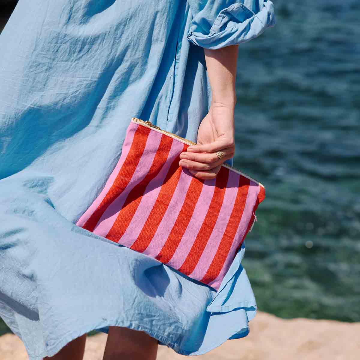 ORKIDÉ / TOMAT Lili platt necessär med ränder i orkidé och tomatrött för wholesale på Faire2